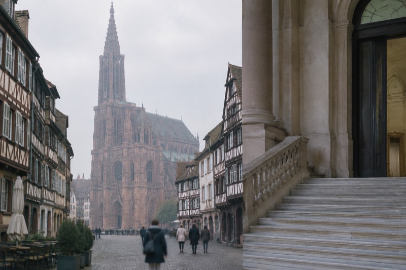 A grand marble staircase and tall doorway inside a classical Strasbourg museum, soft indoor light
