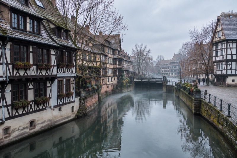 Petite France half-timbered houses along the canal on a cold frosty morning, bare trees, thin mist on the water