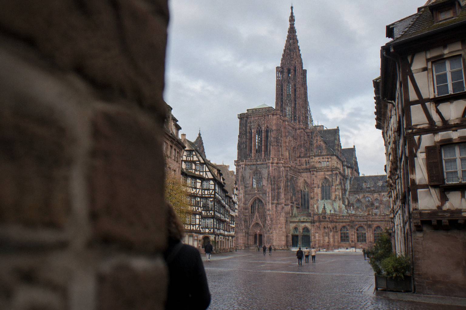 The pink sandstone cathedral spire rising over a cobbled square in Strasbourg