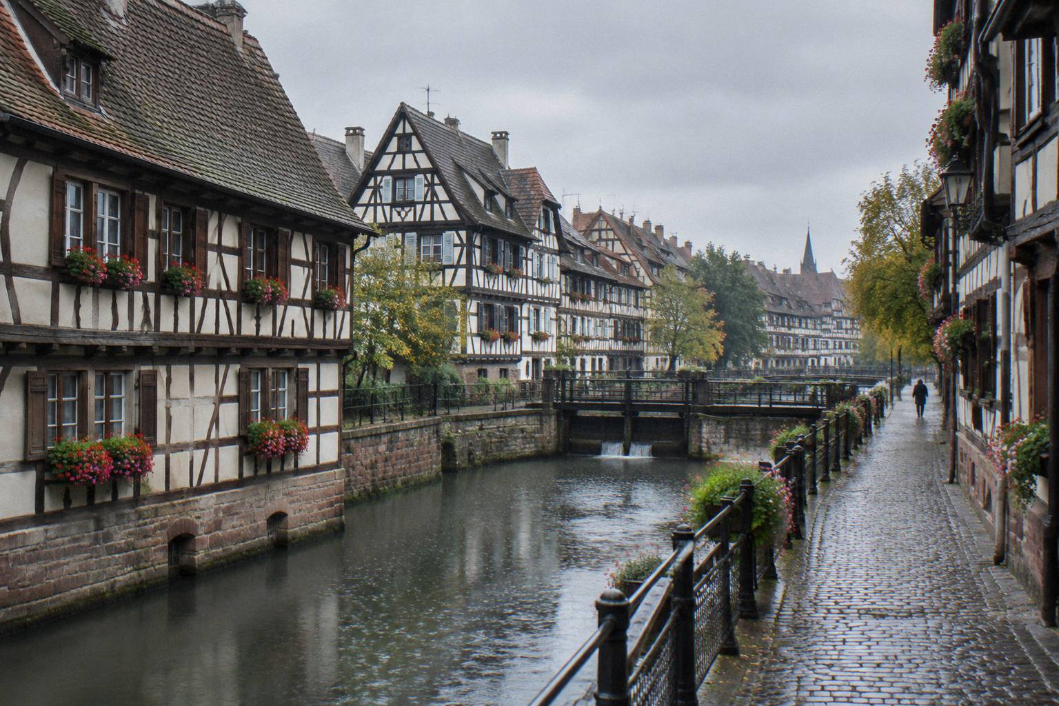 A cobbled canal-side path lined with half-timbered houses in Petite France
