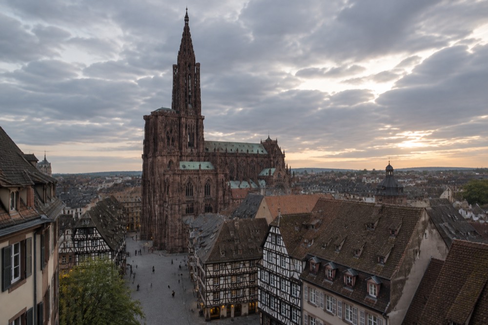 The single spire of Strasbourg Cathedral rising above the rooftops of the Grande Île at dusk