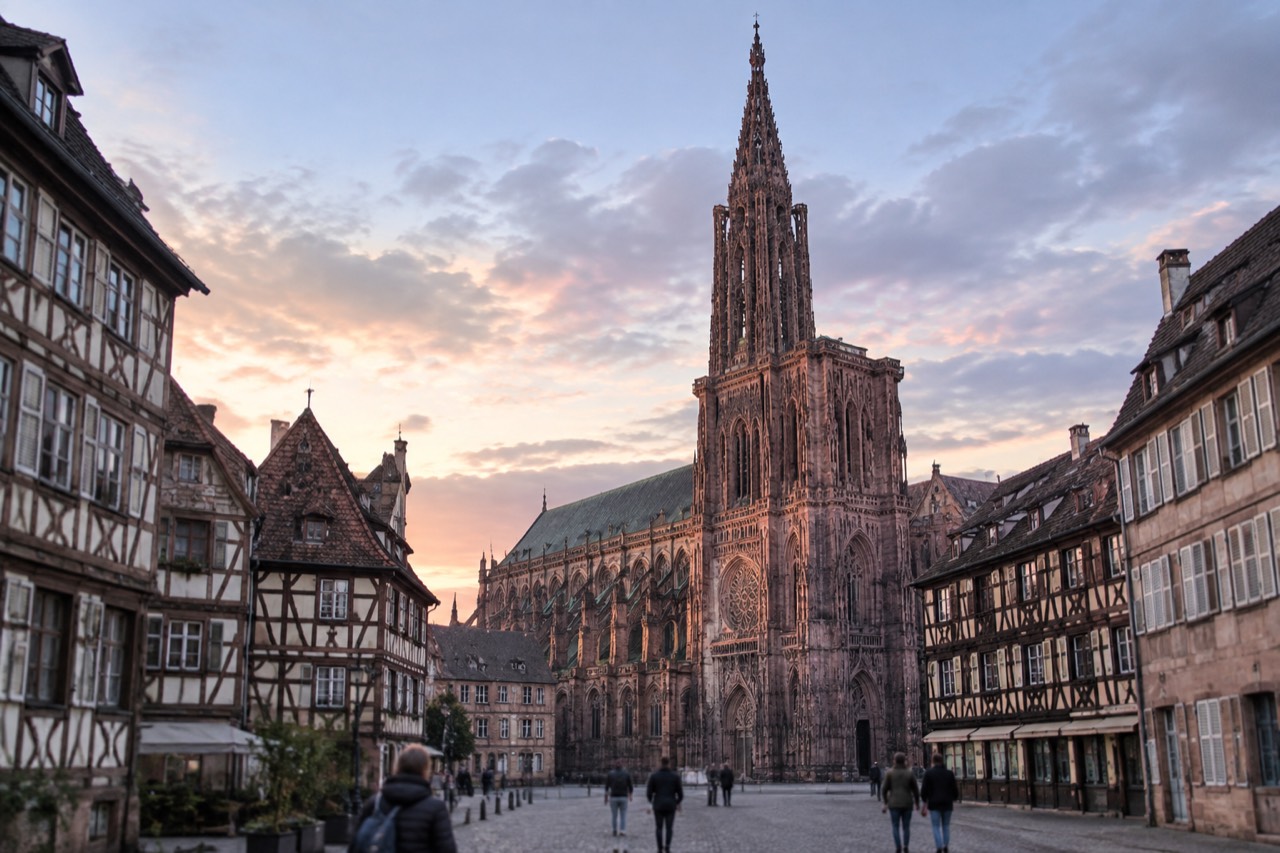 The single spire of Strasbourg Cathedral rising above the rooftops of the Grande Île at dusk