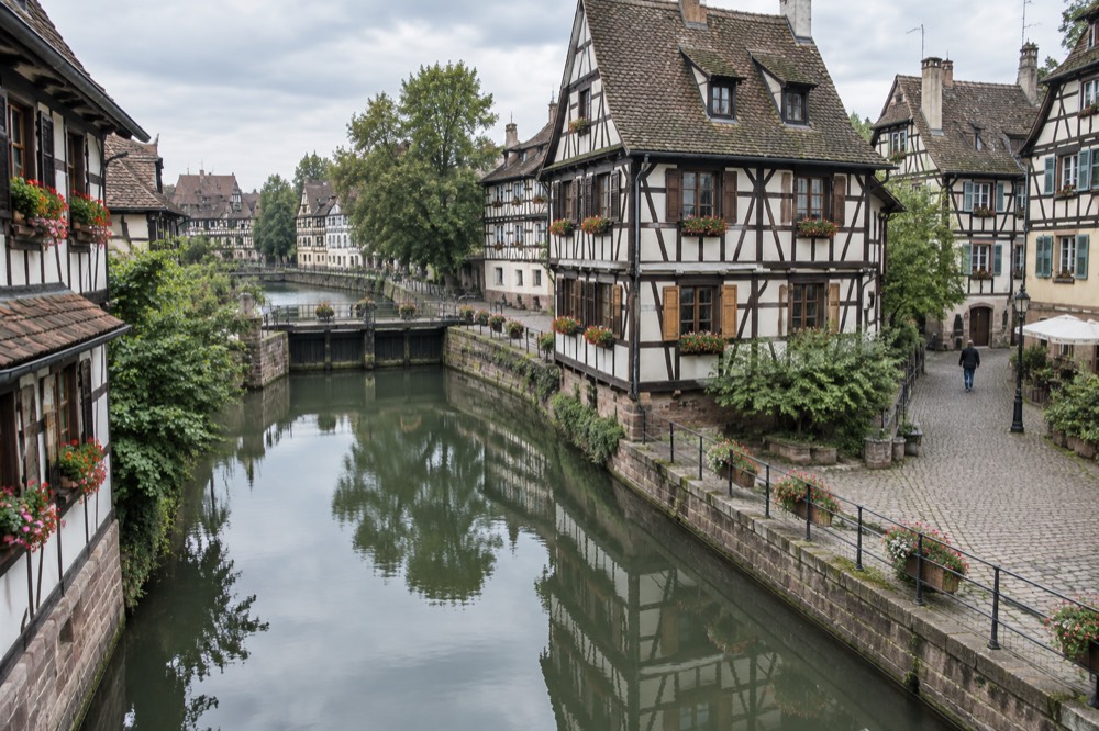 Half-timbered houses reflected in a calm canal in Strasbourg's Petite France quarter