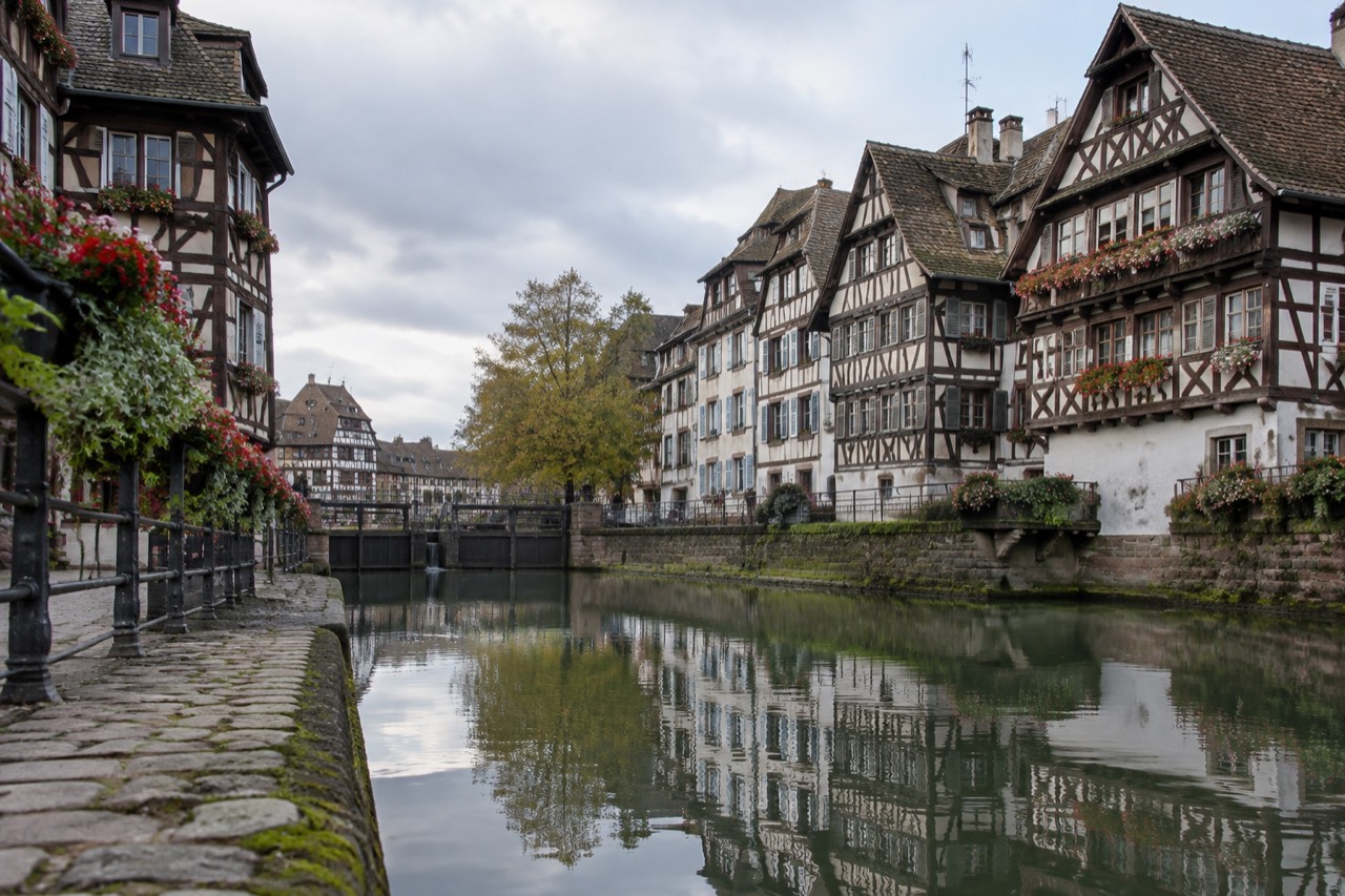 Half-timbered houses reflected in a calm canal in Strasbourg's Petite France quarter