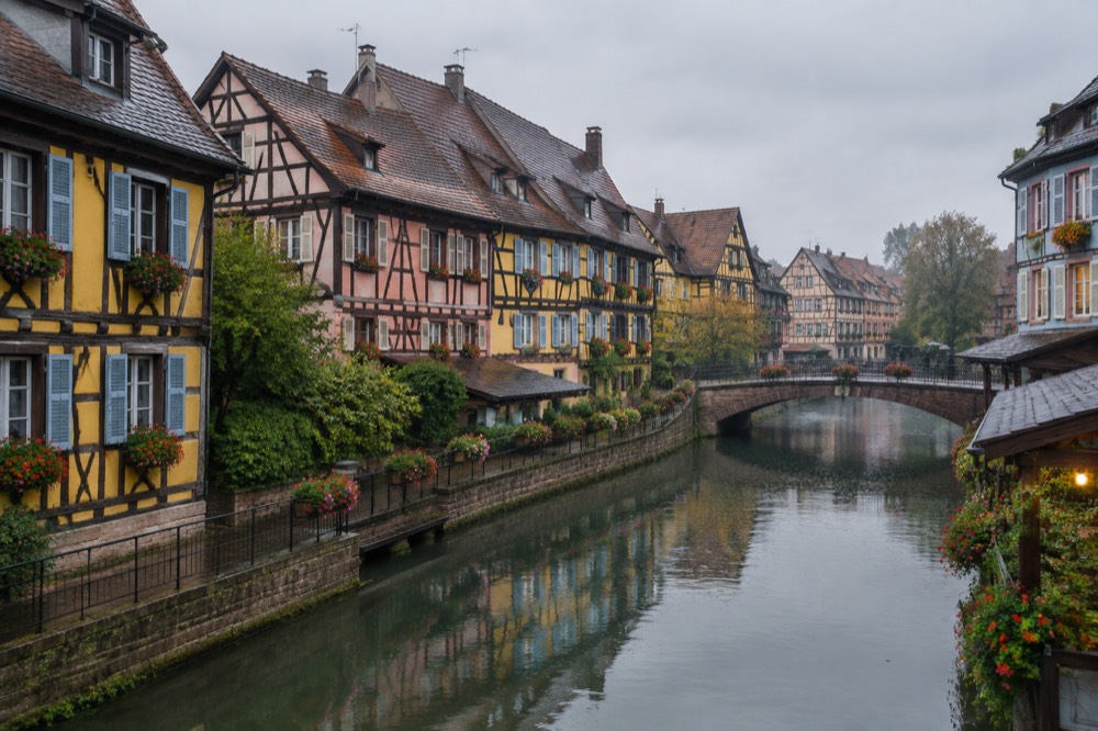 Half-timbered houses with colourful facades reflected in a canal in Colmar's old town