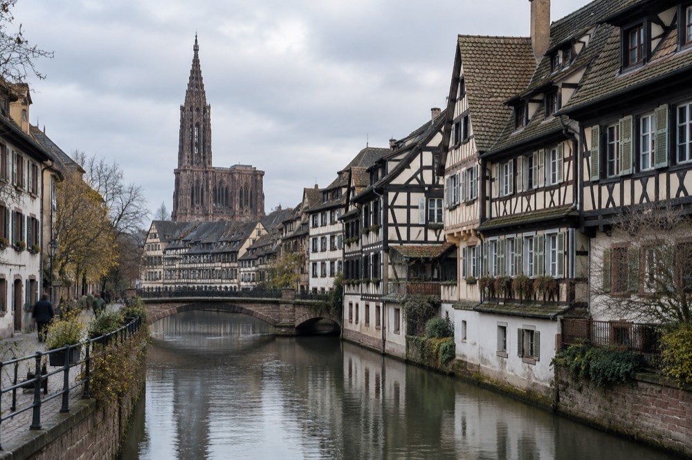 Half-timbered houses along a canal in an Alsatian old town at dusk