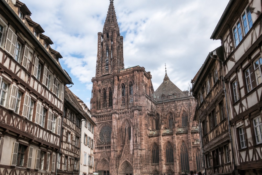 The rose-coloured Gothic façade of Strasbourg Cathedral seen from the square below