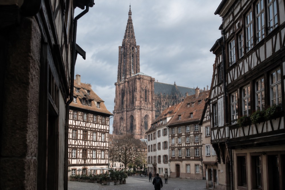 The Gothic spire of Strasbourg Cathedral rising above the red rooftops of the old city