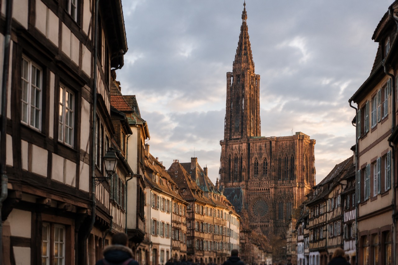 The Gothic spire of Strasbourg Cathedral rising above the red rooftops of the old city