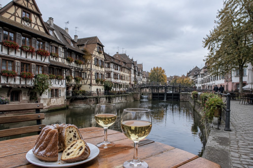 Sliced kougelhopf and glasses of Alsace wine on a wooden winstub table