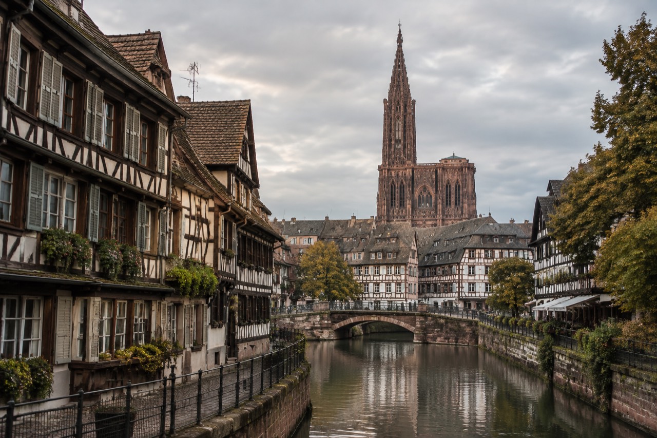 Half-timbered houses along a canal in Petite France, Strasbourg, with the cathedral spire in the background