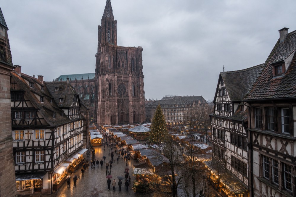 Half-timbered houses and a Christmas market square in Strasbourg at dusk