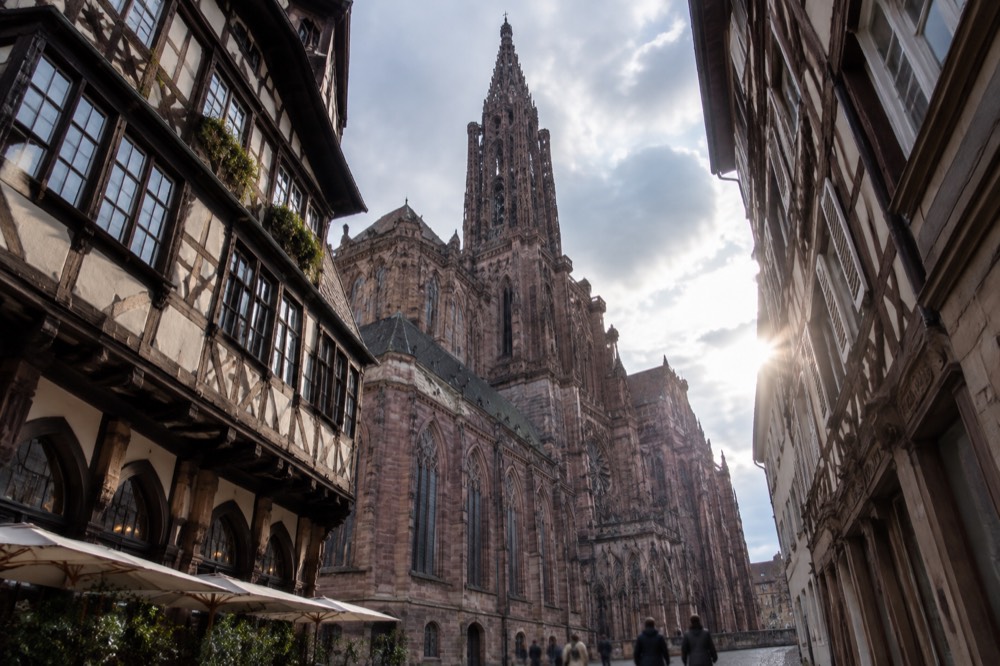 Half-timbered restaurant facade in Strasbourg with chalkboard menu and flower boxes