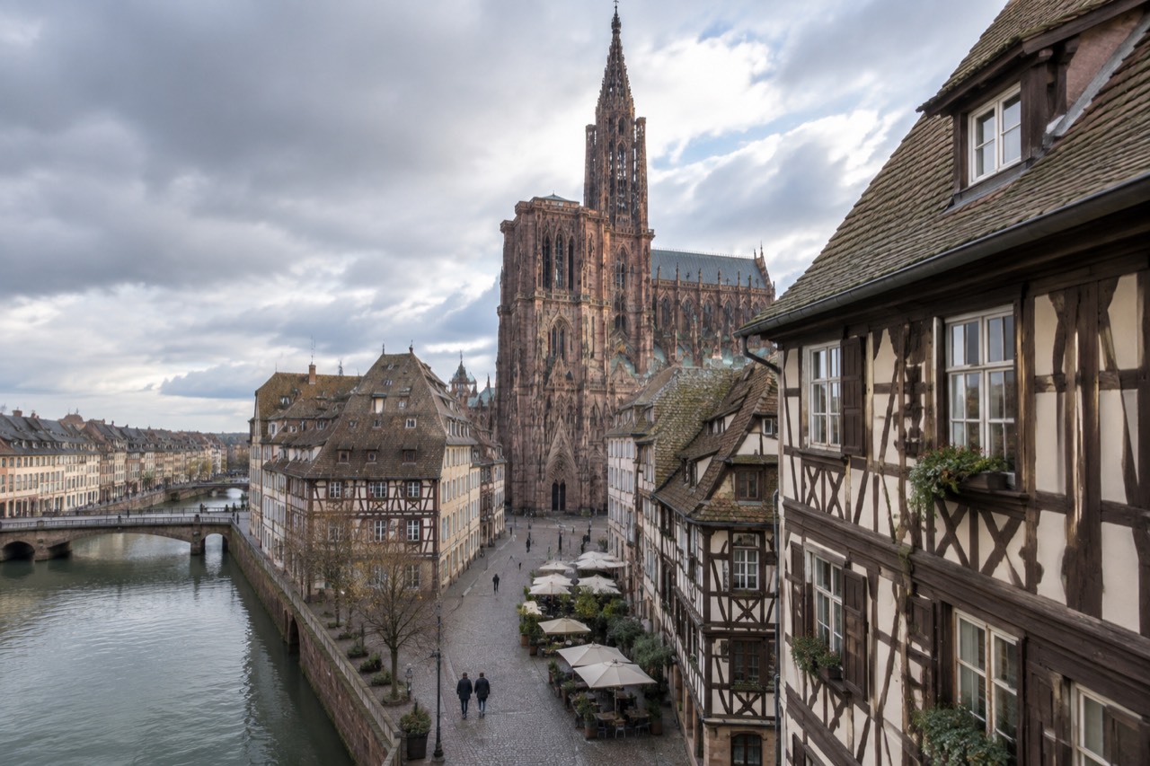 Half-timbered restaurant facade in Strasbourg with chalkboard menu and flower boxes