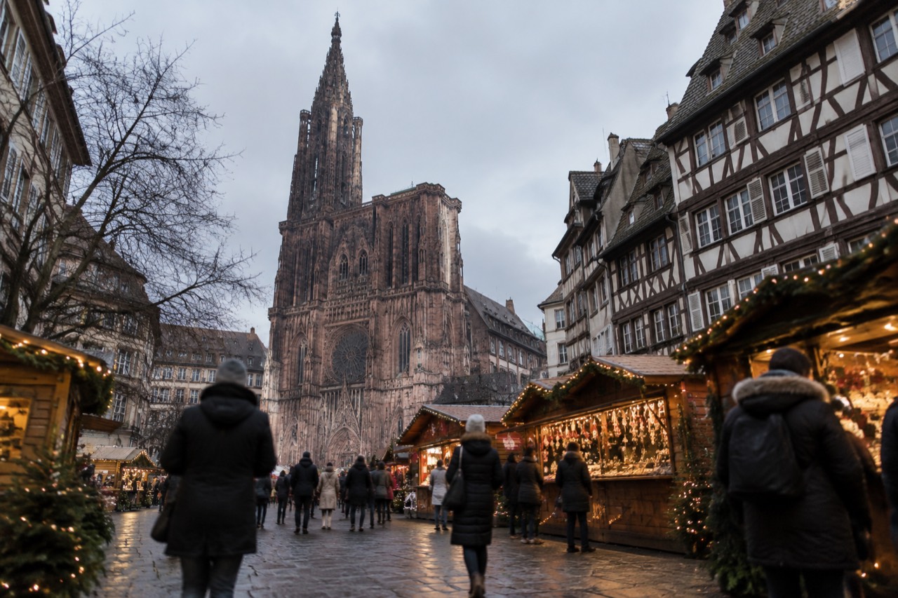 Christmas market chalets with festive lights in a Strasbourg square at dusk