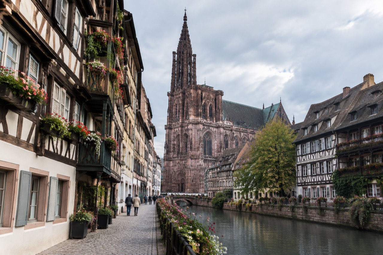 Half-timbered houses along a Strasbourg canal with flowers on the balconies