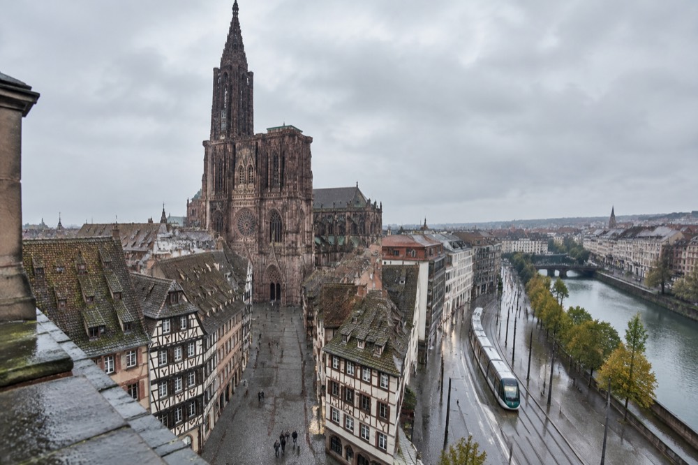 A Strasbourg tram passing modern buildings on a wide boulevard