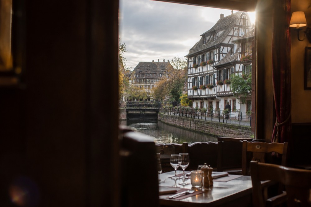 A traditional Alsatian winstub interior with wooden chairs and tables set for dinner