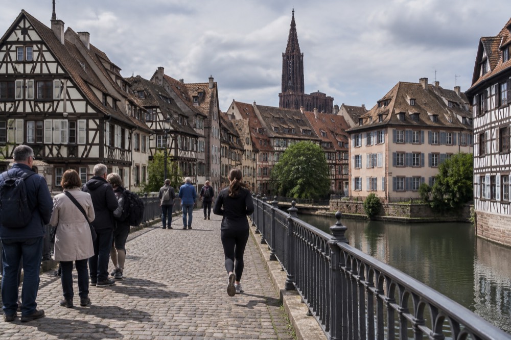 A walking tour group pausing on a bridge between the Grande Ile and the Krutenau
