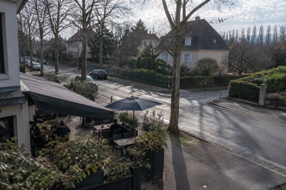 Shaded terrace of a neighbourhood restaurant on a street corner in Robertsau, Strasbourg