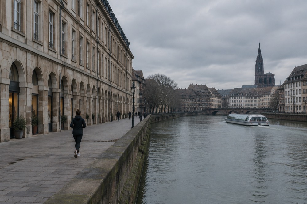 Boat cruising on a calm city river past historic facades