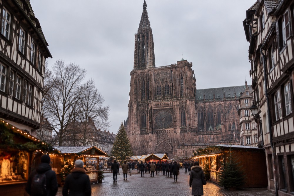 Festive lights and market chalets around Strasbourg cathedral at dusk in December
