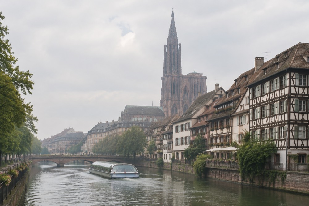 Canal boat passing half-timbered houses along the Ill river in Strasbourg
