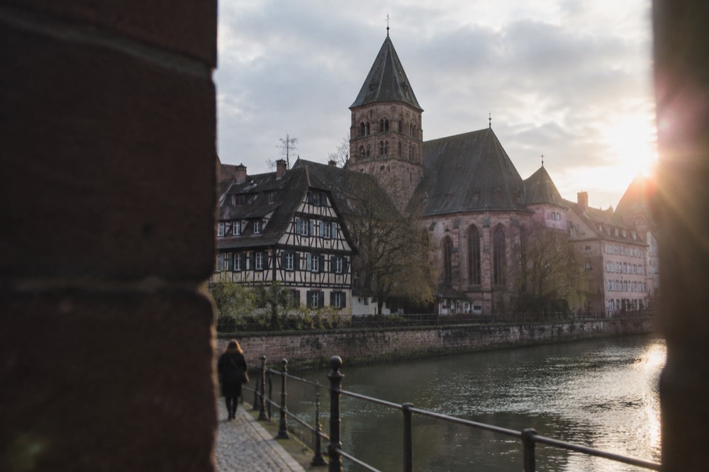 The stone tower and roofline of the Église Saint-Pierre-Le-Jeune rising above the rooftops of central Strasbourg