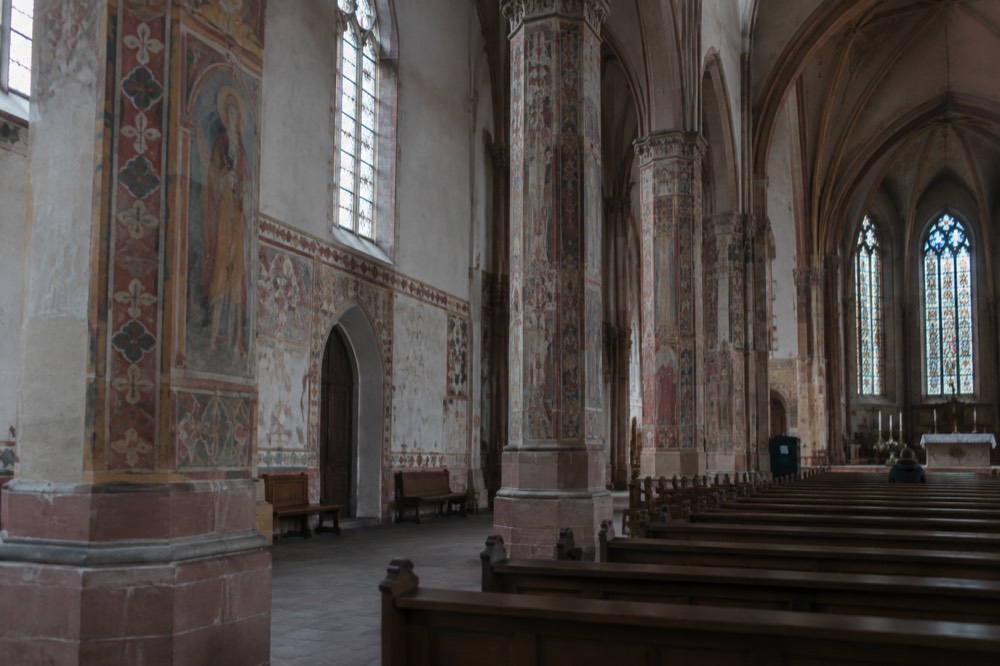 Painted columns and walls inside the Église Saint-Pierre-Le-Jeune seen from the nave