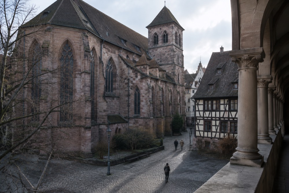 A quiet cloister walkway with stone columns beside the church