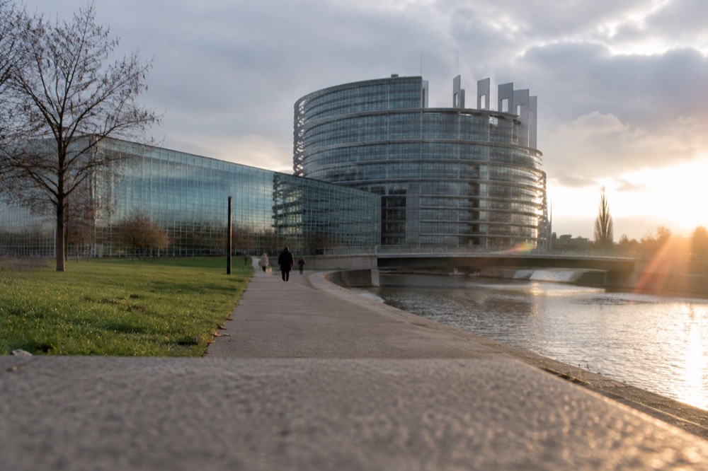 A wide walkway beside the European Parliament building in Strasbourg with lawns and modern architecture