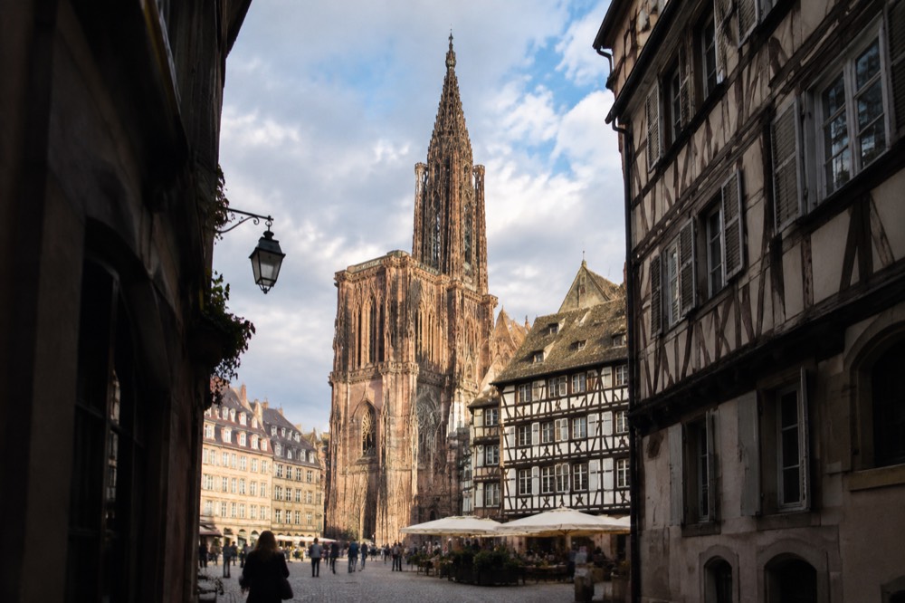The spire of Strasbourg Cathedral rising above the old town rooftops at the end of the day