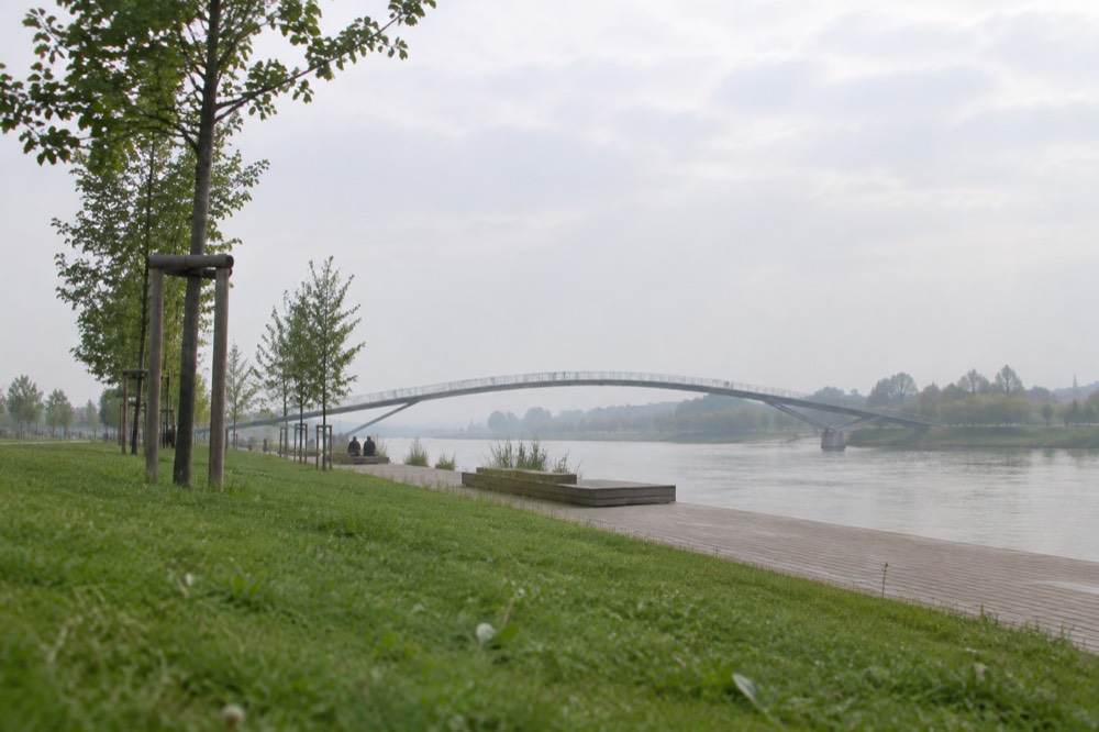 A curved pedestrian bridge crossing the Rhine between France and Germany