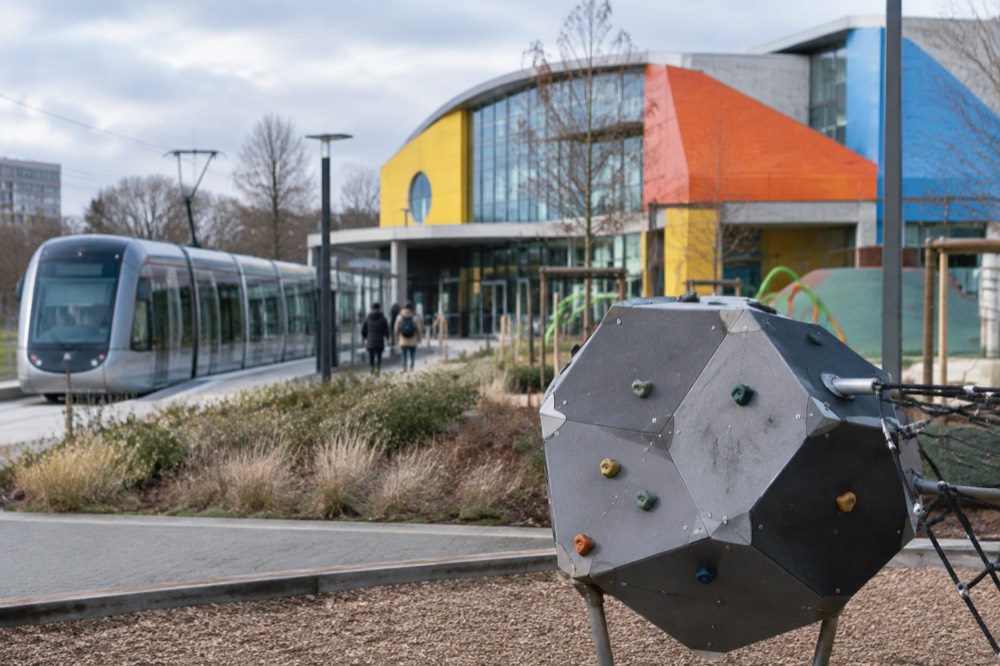 A bright exhibition hall with hands-on activity stations arranged in zones