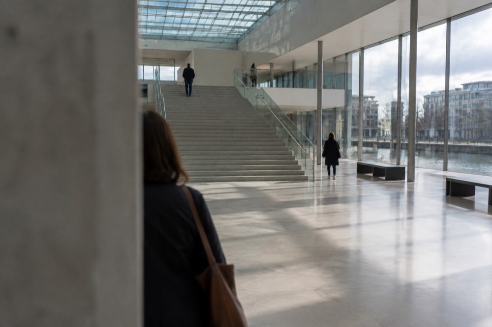 A spacious museum atrium with a wide staircase and daylight from a high glass roof
