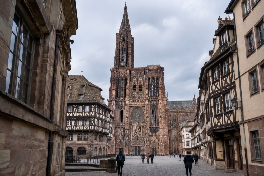 Cathedral west front seen from a cobbled square with the museum buildings at the edge