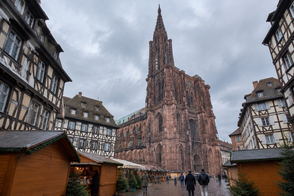 Cobbled square with market chalets and the cathedral spire above the rooftops