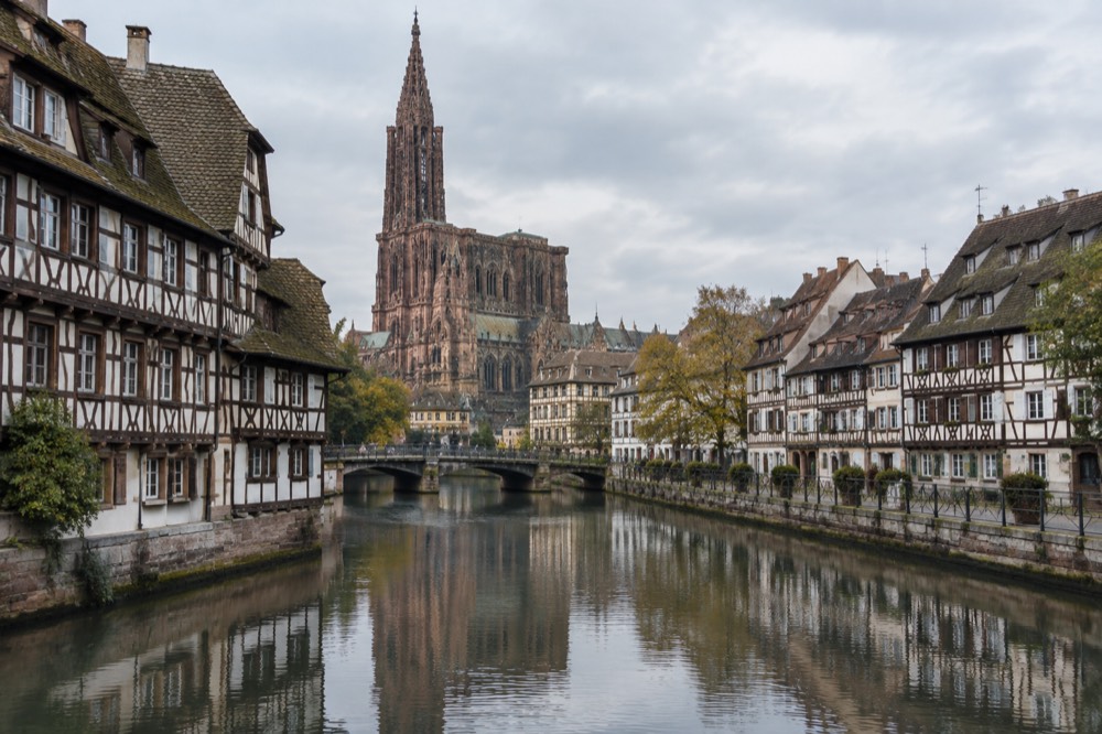 Riverside half-timbered buildings reflected in the Ill river in Strasbourg