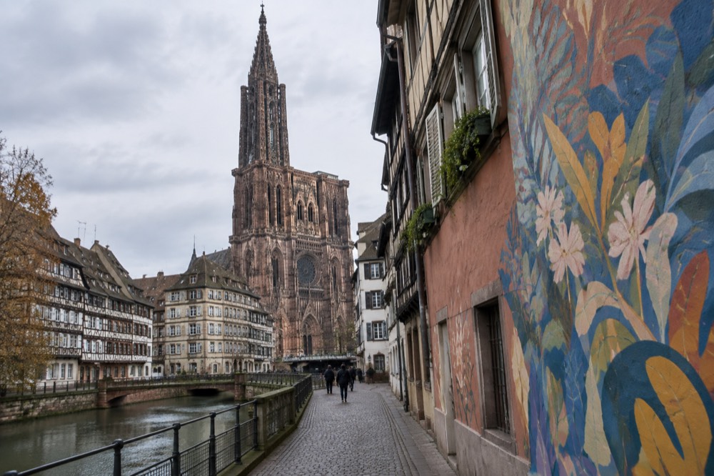 Painted building wall in a Strasbourg street with a large colourful mural across several storeys of brickwork.