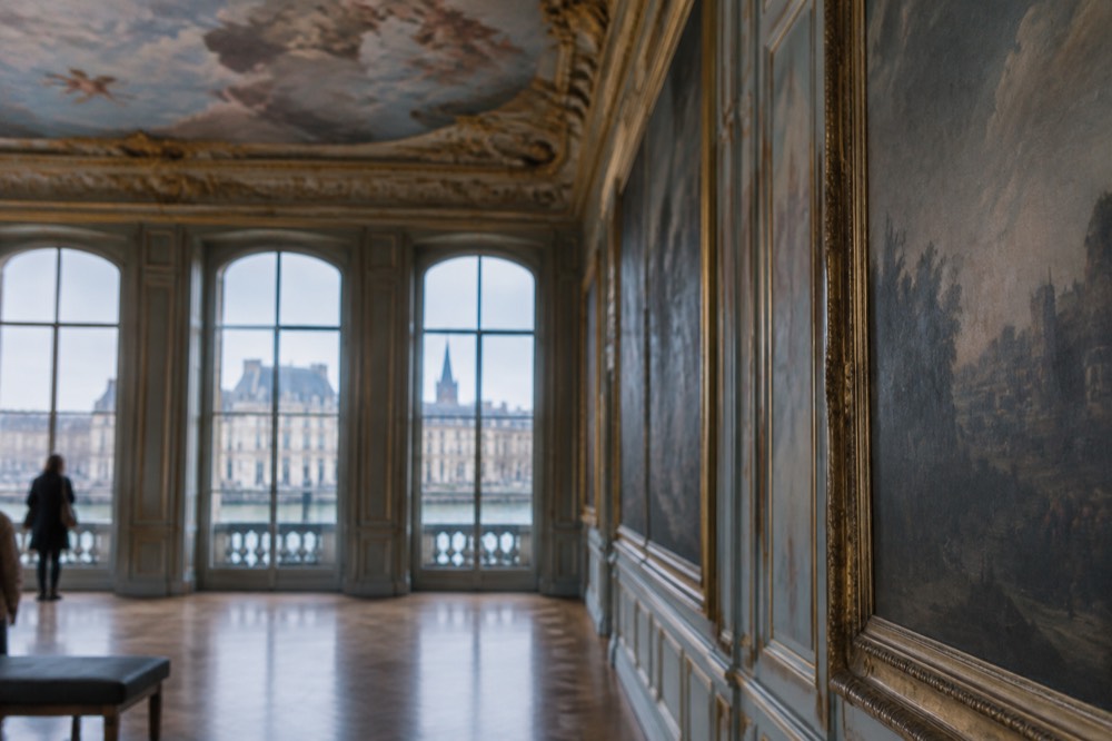 A painted ceiling and gallery wall inside a museum room in Palais Rohan
