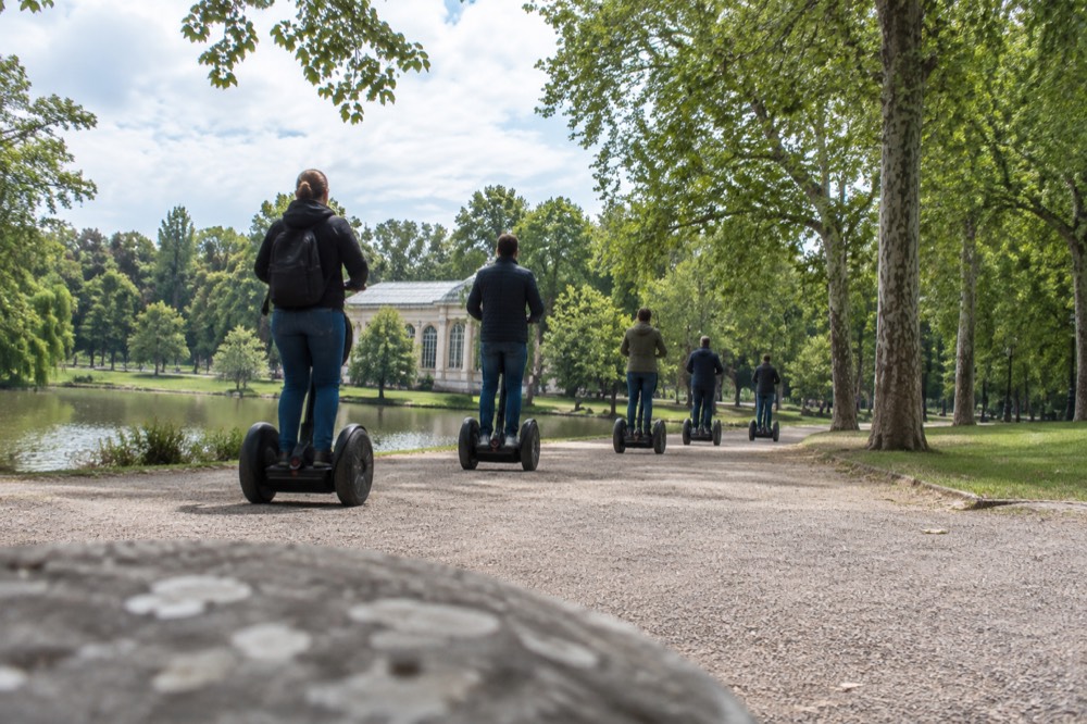 Group of segway riders moving along a wide park path