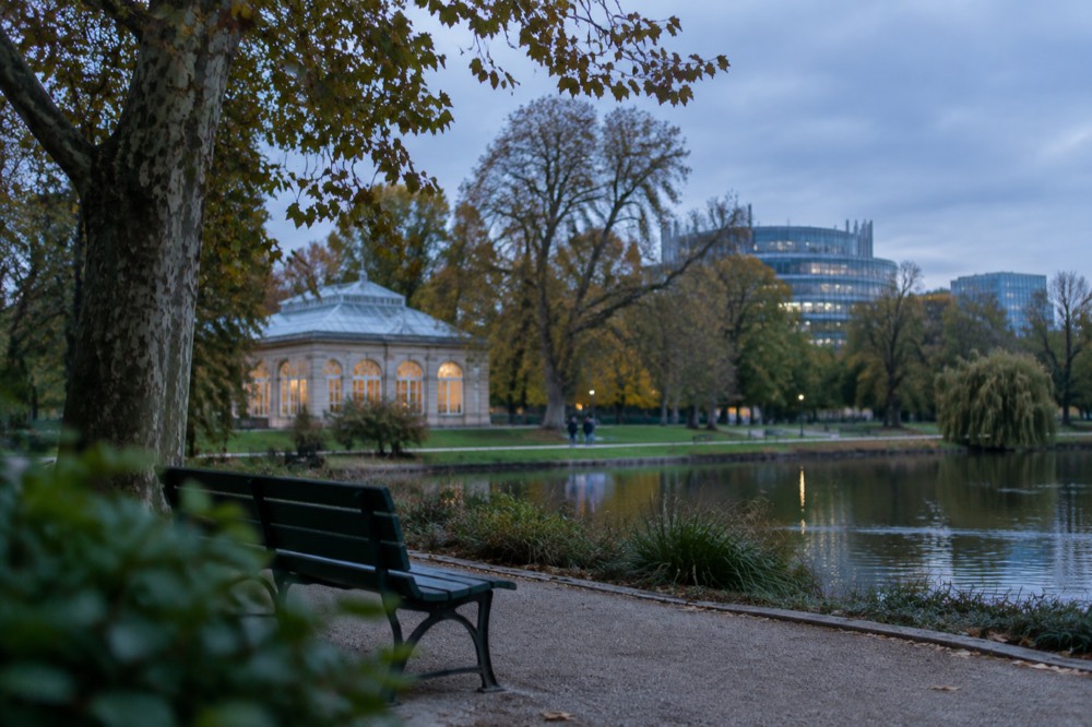 Modern glass buildings of the European institutions seen beyond park trees