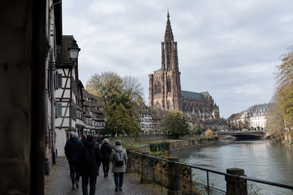 Guided walking group on a riverside path near a city park in Strasbourg