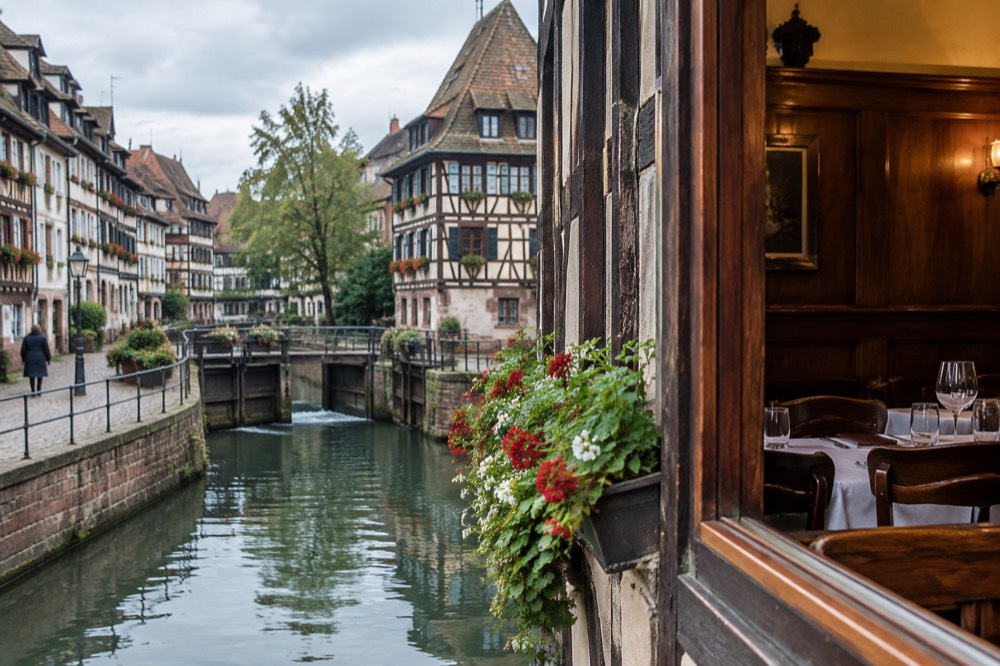 A traditional winstub interior with dark wood panelling and set tables in Strasbourg