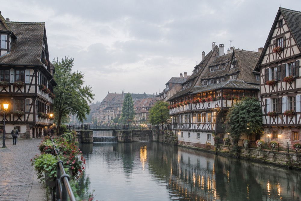 Evening lights reflecting in a canal between half-timbered houses in Petite France, Strasbourg