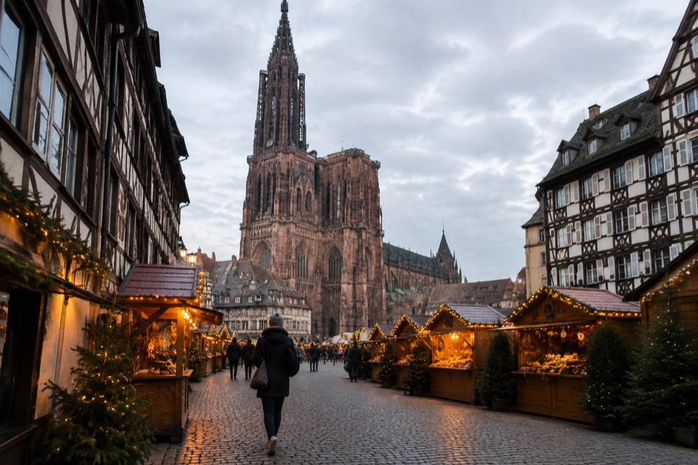 Festive market chalets and evening lights in a square in Strasbourg old town