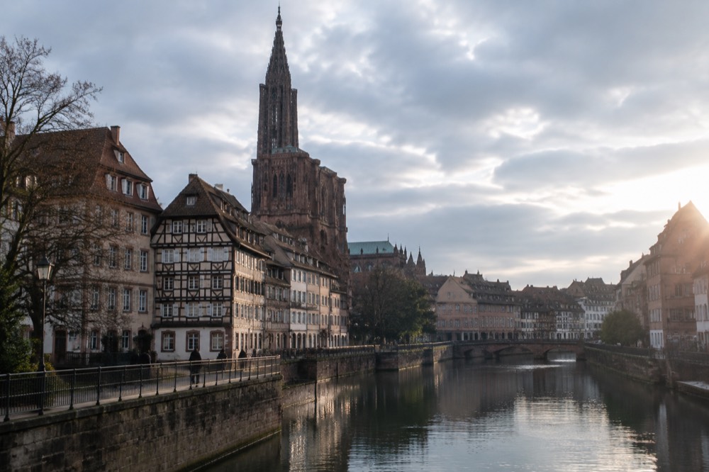 Riverside quay along the Ill in Strasbourg with old buildings reflected in the water