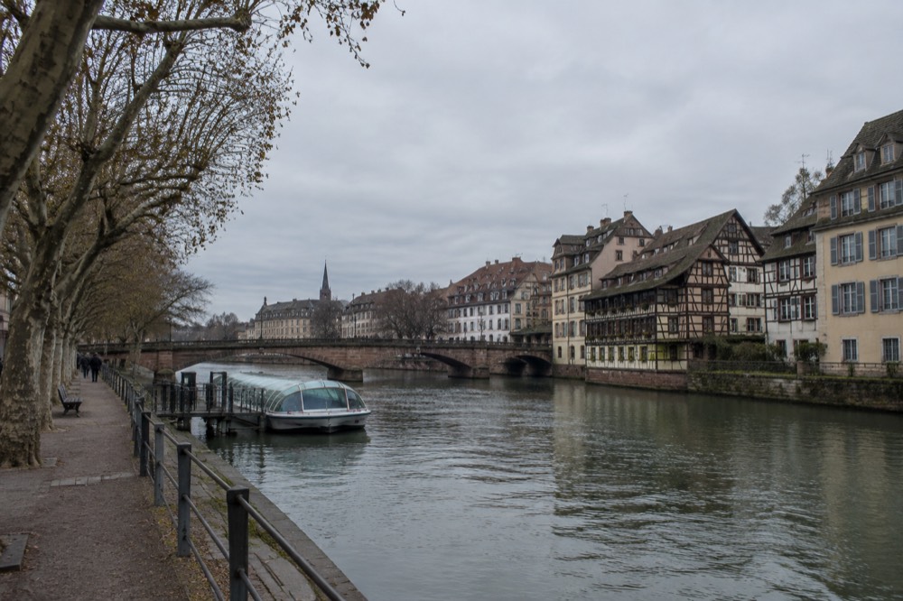 Half-timbered houses beside the Ill with a stone bridge crossing the river