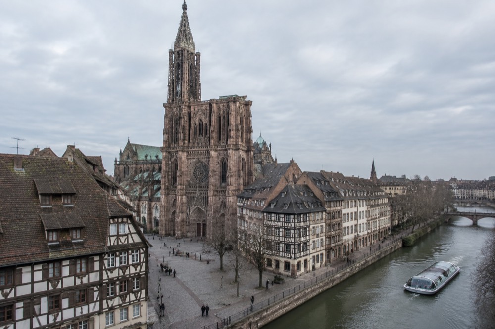 Passenger boat travelling along the Ill past riverside buildings in Strasbourg