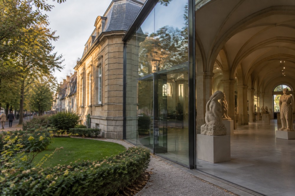 Sculpture gallery with stone figures displayed in a vaulted museum hall